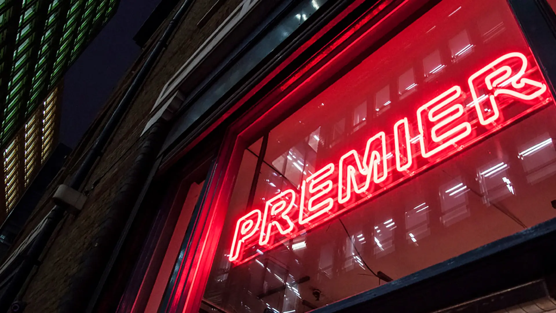 Premier logo in red neon above the front door